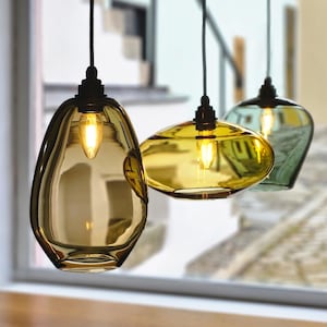 May include: A set of three ceramic mugs with a speckled, matte finish. The mugs are in shades of cream, light gray, and dark gray. Each mug has a simple, minimalist design, perfect for coffee or tea.