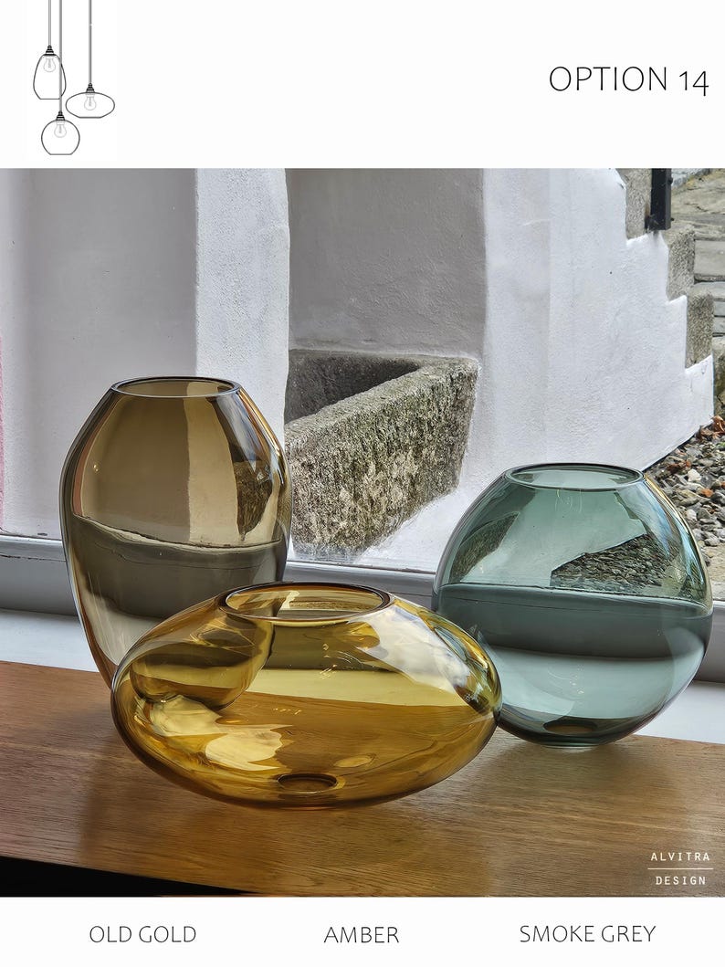 May include: Three glass vases in amber, old gold, and smoke grey hues. The amber vase is oval-shaped, the old gold vase is tall and irregular, and the smoke grey vase is spherical. The vases are displayed on a wooden surface. The text "OPTION 14" is visible.