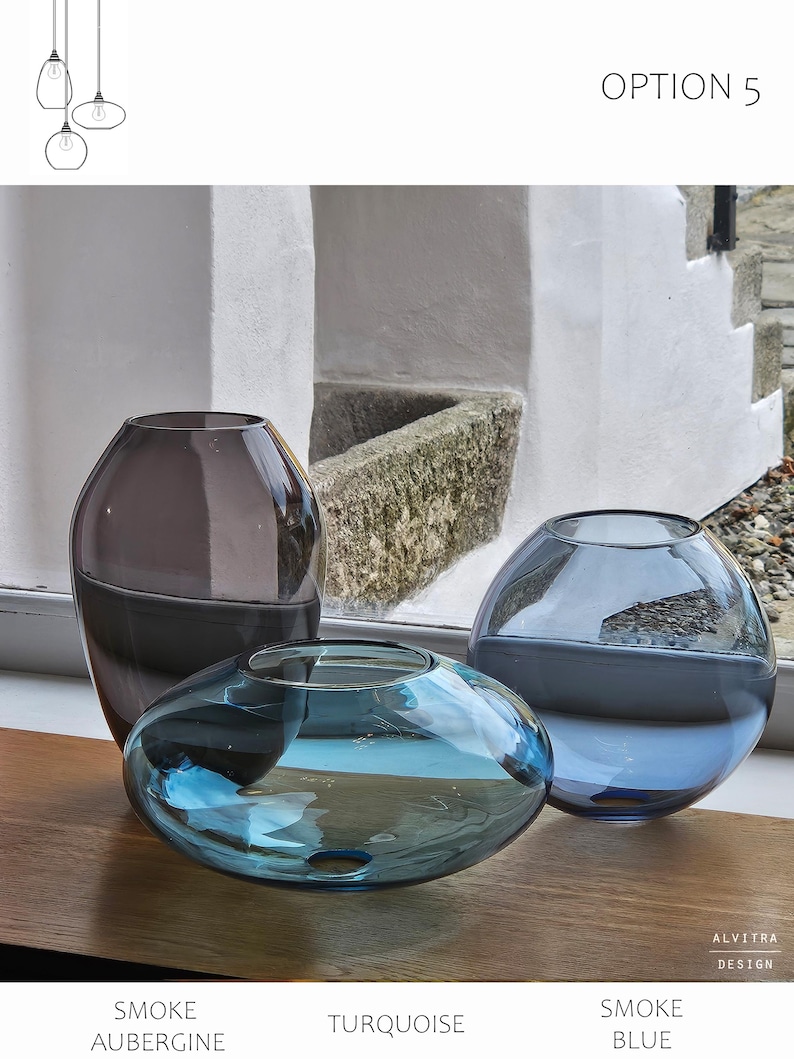May include: Three glass vases in shades of gray, turquoise, and blue are displayed. The vases have rounded shapes, with the turquoise vase being the flattest. The text "OPTION 5" is visible. The vases are on a wooden surface.