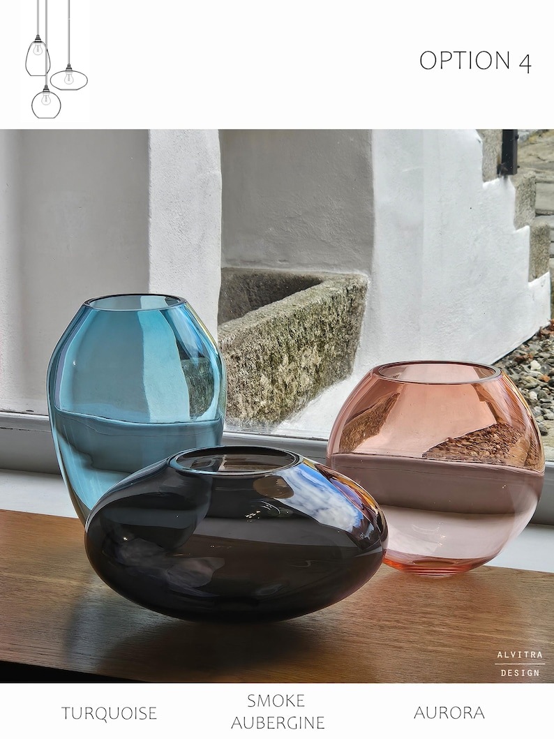 May include: Three glass vases in turquoise, smoke aubergine, and aurora colors. The turquoise vase is tall and cylindrical, the smoke aubergine vase is oval, and the aurora vase is round. The vases are displayed on a wooden surface. The text "OPTION 4" is visible.