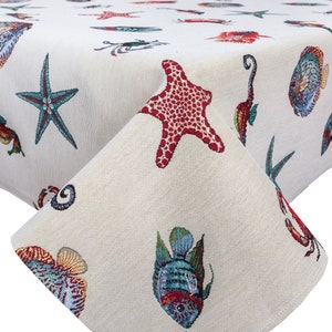 May include: A white tablecloth with a sea life pattern. The pattern includes starfish, seahorses, fish, and crabs. The tablecloth is made of a woven fabric.