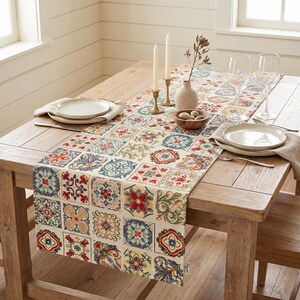 May include: A wooden dining table is set with a decorative table runner featuring a colourful, patterned tile design. The table is set with plates, silverware, candles, and a small vase with decorative elements.