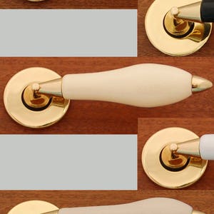 Peut inclure: Cinq poignées de porte avec des boutons en céramique de différentes couleurs. Les poignées sont toutes dorées et ont une base ronde. Les boutons sont blancs, noirs, crème, blancs et crème.
