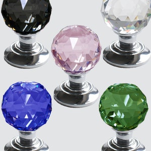 Può includere: Cinque pomelli per porte in cristallo di diversi colori. I pomelli sono rotondi e hanno un design sfaccettato. I pomelli sono montati su una base argentata.