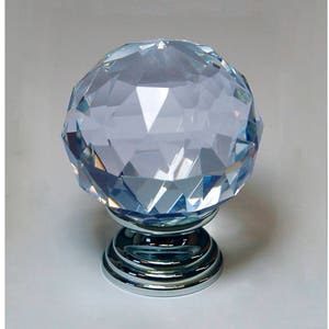 May include: A clear crystal cabinet knob with a faceted design and a chrome base.