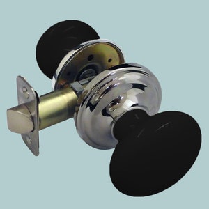 Pode incluir: Uma maçaneta de porta cromada com detalhes pretos. A maçaneta tem formato redondo e uma alavanca. A alavanca está presa a uma placa redonda com uma fechadura.