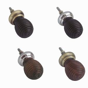 May include: Four wooden cabinet knobs with a ribbed design. Each knob has a different metal finish: brass, silver, brass, and silver.