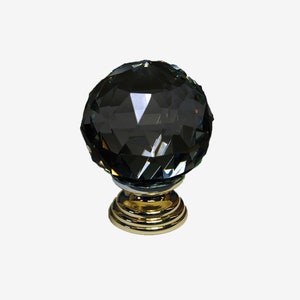 May include: A black crystal cabinet knob with a gold base. The knob is faceted and has a round shape.