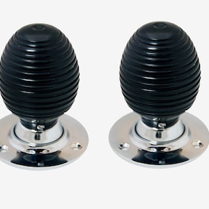 May include: Pair of black and chrome door knobs with a ribbed design.