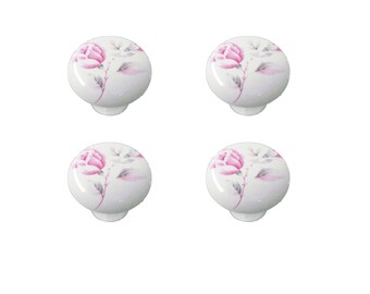 Puede incluir: Cuatro pomos de armario de cerámica blanca con un diseño floral de rosa rosa.