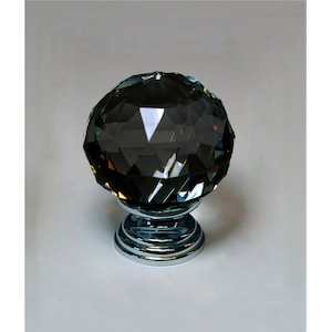 May include: A dark grey crystal cabinet knob with a faceted design and a chrome base.