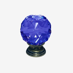 Peut inclure: Un bouton de cabinet en cristal bleu avec un design facetté et une base en laiton antique.