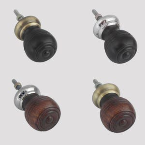 May include: Four cabinet knobs with different finishes. Two knobs are black with a brass base and two knobs are brown with a silver base.