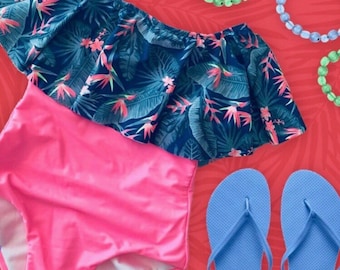 Peut inclure: Un maillot de bain rose et bleu avec un imprimé tropical et un haut à volants. Le maillot de bain est associé à des tongs bleues.
