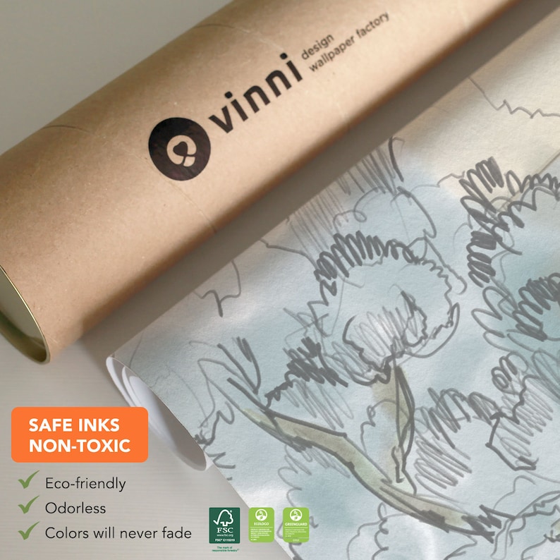 Op de afbeelding: Een rol behang met een lichtblauwe achtergrond en een grijs en groen bloemenpatroon. Het behang is gelabeld "vinni design wallpaper factory". De tekst "SAFE INKS NON-TOXIC" staat op een groen label met een vinkje naast de woorden "Eco-friendly", "Odorless" en "Colors will never fade".
