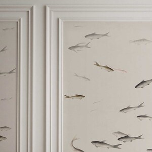 May include: A white wall with a subtle beige background featuring a repeating pattern of gray fish in various sizes and positions. The fish are painted in a watercolor style, giving the design a delicate and ethereal feel.