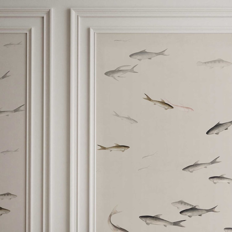 May include: A white wall with a subtle beige background featuring a repeating pattern of gray fish in various sizes and positions. The fish are painted in a watercolor style, giving the design a delicate and ethereal feel.