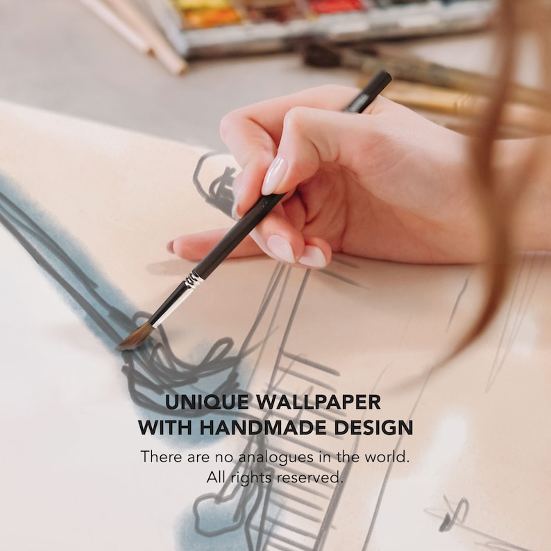 Op de afbeelding: Een hand houdt een penseel boven een tekening op een wit oppervlak. De tekening is van een persoon. De tekst "UNIQUE WALLPAPER WITH HANDMADE DESIGN" staat onder de tekening. De tekst "There are no analogues in the world. All rights reserved." staat onder de tekst.