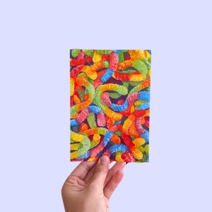 May include: A close-up of a painting depicting a colorful assortment of gummy worms. The worms are arranged in a random pattern, creating a vibrant and playful design.