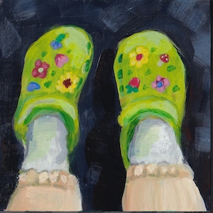 May include: A pair of lime green clogs adorned with colorful floral designs, including pink, yellow, and blue flowers, and a small mushroom. The clogs are worn with white socks with a ruffled trim, set against a dark background.