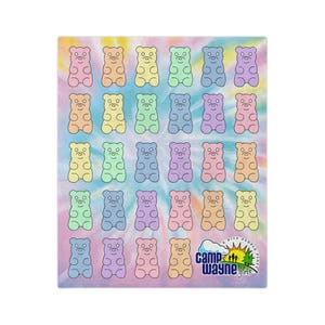 May include: A rectangular blanket featuring a tie-dye background in pastel shades of pink, blue, yellow, and green. The surface is covered in a repeating grid pattern of outlined gummy bear shapes in various colors. The Camp Wayne for Girls logo is printed in the bottom right corner.