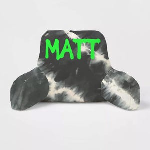 May include: Black and white tie-dye fabric lumbar pillow with the name "MATT" written in green paint.