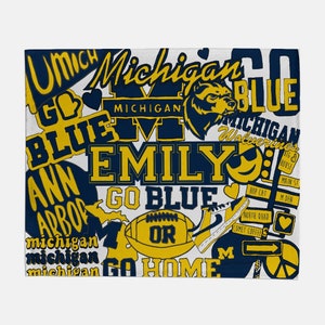 K&ouml;nnte beinhalten: Ein wei&szlig;er Hintergrund mit einer Collage aus blauem und gelbem Text und Bildern. Der Text enth&auml;lt "Go Blue", "Michigan", "Wolverines", "Ann Arbor", "Emily" und "Go Home". Die Bilder zeigen einen Fu&szlig;ball, einen B&auml;ren und ein Herz.