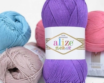 May include: A selection of colourful yarn skeins in shades of purple, pink, blue, and beige. The yarn is labelled with the brand name "Alize Bahar". The skeins are tightly wound and appear soft, suitable for various knitting and crochet projects.