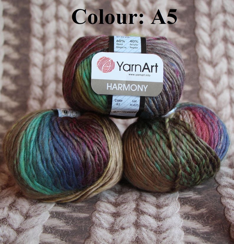 May include: Three balls of YarnArt Harmony yarn in colour A5. The yarn is a blend of wool and acrylic, with a mix of colours including brown, green, blue, and red. The label indicates the yarn composition and brand.
