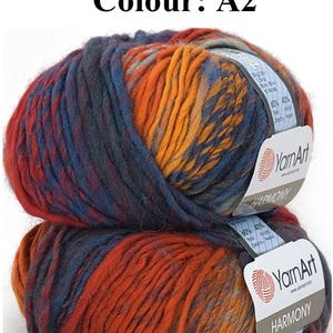 May include: Two balls of YarnArt Harmony yarn in colour A2. The yarn is a blend of red, orange, and blue. The labels on the yarn balls indicate the composition of the yarn. The yarn is suitable for various knitting and crochet projects.