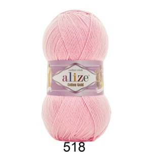 May include: A ball of light pink Alize Cotton Gold yarn. The yarn is wrapped with a label that reads "Cotton Club" and "Alize Cotton Gold". The number "518" is printed at the bottom of the ball of yarn.