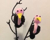 Two pom pom vultures sitting in a tree with skeleton diorama
