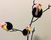 Three pom pom vultures sitting in a tree with large skull diorama