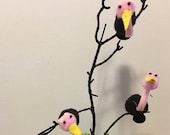 Three pom pom vultures sitting in a tree with skulls diorama