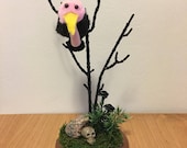 One lonely pom pom vulture sitting in a tree diorama