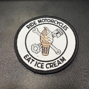 May include: Round patch with the text "RIDE MOTORCYCLES EAT ICE CREAM" in a black font. The patch features a crossed wrench and piston with an ice cream cone in the center. The patch has a white background with a black border.