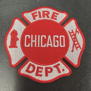 Pu&ograve; includere: Una toppa ricamata circolare con un design a croce di Malta rosso e bianco. Il cerchio centrale mostra il testo CHICAGO in bianco. Le sezioni superiore e inferiore riportano FIRE e DEPT. Un idrante rosso e una scala sono sui pannelli laterali.