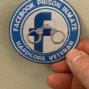 Pode incluir: Um remendo bordado azul e branco com o texto "Facebook Prison Inmate Hardcore Veteran" e um "F" estilizado com algemas ao redor.