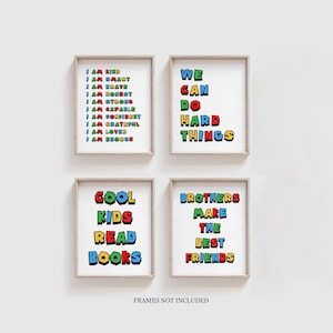 May include: Four colorful framed prints with motivational messages in a retro video game style. The prints read "I am kind, I am smart, I am brave, I am honest, I am strong, I am capable, I am confident, I am grateful, I am loved, I am enough", "We can do hard things", "Cool kids read books", and "Brothers make the best friends".