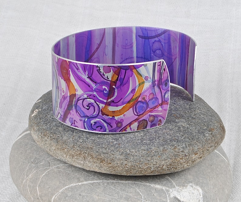 Cuff bracelet; hand painted anodised aluminium; abstract floral pattern; purple; pinks; orange; Irises; Boho; artistic.