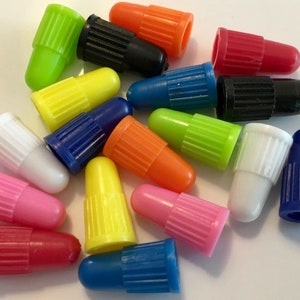 May include: Assortment of colorful valve stem caps in various colors including red, pink, yellow, green, blue, white, black and orange.