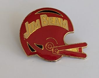 Vintage Jim Beam reklamnål – Röd fotbollshjälmdesign, whiskyflaska, emaljmärke, logotyp, kavaj, sprit, alkoholreklam, drycker
