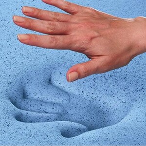 May include: A close-up of a blue memory foam mattress topper. A hand is pressing into the foam, showing how soft and comfortable it is.