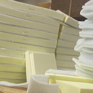 May include: A stack of white foam padding and a stack of beige foam padding. The foam padding is used for upholstery and furniture making.