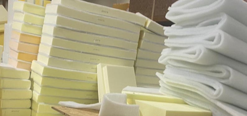 May include: A stack of white foam padding and a stack of beige foam padding. The foam padding is used for upholstery and furniture making.