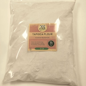 May include: A white plastic bag filled with tapioca flour. The bag has a label that says "Tapioca Flour" and "Farin Manyok". The label also says "Great for thickening soup and sauce - perfect for baking and porridge." The label also says "100% Natural" and "3 LB".