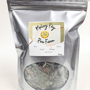 May include: A silver foil pouch with a clear window showing dried herbs. The label says "Melanj Fey Pou Fanm" with "35 gr." at the bottom. Additional text includes "Neem, Twompet, Pa Kongo, and much more."