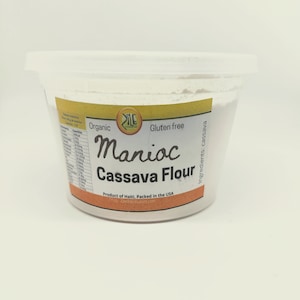 以下が含まれることがあります： 黄色のラベルが付いた白いプラスチック容器。ラベルには「Organic Gluten free Manioc Cassava Flour Product of Haiti. Packed in the USA Ziledistributors.com Ingredients: cassava」と書いてあります。