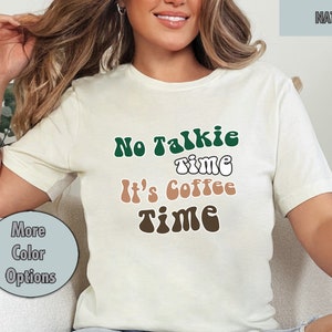 Könnte beinhalten: Ein weißes T-Shirt mit dem Text "No Talkie Time It's Coffee Time" in grüner, weißer und brauner Retro-Schrift.