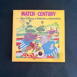 May include: A vintage book cover with the title "Match of the Century" from Walt Disney's Bedknobs and Broomsticks. The cover features cartoon characters, including a hippo, lion, and elephant playing a game on a colorful field, set against a yellow background.